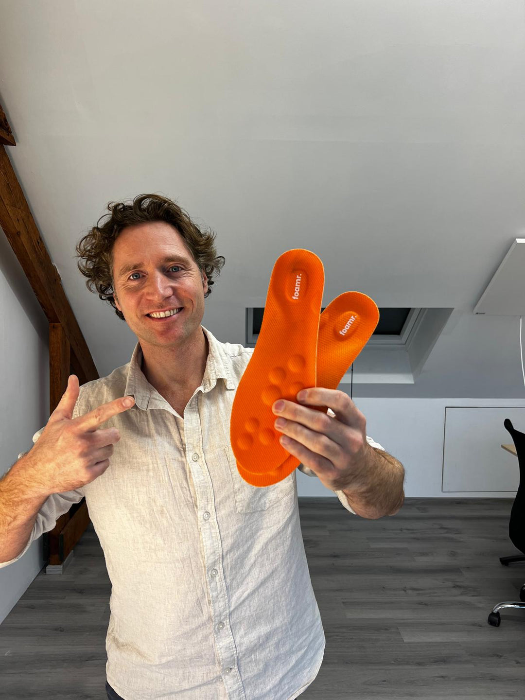Oprichter van Foamr met oranje en zwarte inlegzolen in de hand